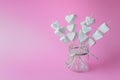 Heart shaped marshmallows on wooden sticks on pink paper background Royalty Free Stock Photo