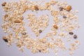 Heart shaped muesli scattered on gray background. Healthy breakfast for healthy life Royalty Free Stock Photo