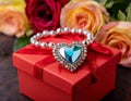 a heart shaped necklace sits on top of a red gift box of roses Royalty Free Stock Photo