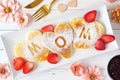 Mothers Day breakfast heart shaped pancakes with MOM letters, top view table scene on white wood