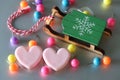 Heart-shaped paper clips, toy wooden sledges and colorful safety pins