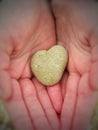 Heart-shaped pebble in a child's hands Royalty Free Stock Photo