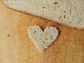 Heart shaped piece of bread in front of full bread