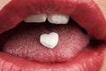 Heart shaped pill in woman's mouth