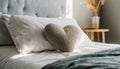 Heart-shaped pillow on top of bed, Soft and cozy. Minimalistic bedroom Royalty Free Stock Photo