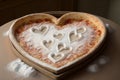 a heart-shaped pizza with a light dusting of powdered sugar, ready to be served at a wedding reception.