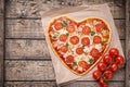 Heart shaped pizza margherita with tomatoes and Royalty Free Stock Photo