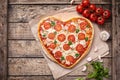 Heart shaped pizza margherita vegetarian love concept with mozzarella, tomatoes, parsley and garlic composition on Royalty Free Stock Photo