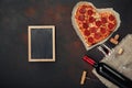 Heart shaped pizza with mozzarella, sausagered with a bottle of Royalty Free Stock Photo