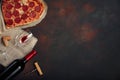 Heart shaped pizza with mozzarella, sausagered with a bottle of wine and wineglas on rusty background Royalty Free Stock Photo