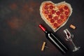 Heart shaped pizza with mozzarella, sausagered with a bottle of wine and wineglas. Valentines day greeting card on rusty backgroun Royalty Free Stock Photo