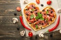 Heart-shaped pizza, Valentine`s Day. With vegetables. A concept of tasty and healthy food with love. Free-lay