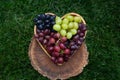 heart-shaped plate with colorful, tasty, ripe grapes