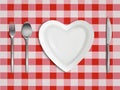 Heart shaped plate, fork, spoon and knife top view Royalty Free Stock Photo