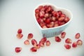 Heart shaped plate, red pomegranate fruit Royalty Free Stock Photo