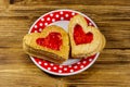 Heart shaped puff cookies with jam on wooden table. Dessert on Valentine`s Day