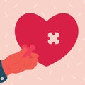 Heart shaped puzzle. Man hand inserts piece