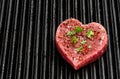 Heart shaped raw beef meat with spices on grill tray. Healthy lifestyle or organic food concept for meat lovers Royalty Free Stock Photo