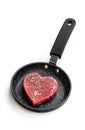 Heart shaped raw beef meat with spices on small frying pan isolated on white. Healthy lifestyle or organic food concept for meat Royalty Free Stock Photo