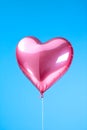 Heart shaped red air balloon flying in blue sky. Symbol of love. St Valentine\'s day concept Royalty Free Stock Photo