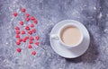Heart-shaped red candy and a cup of coffee on a concrete background. Top view. Copy space Royalty Free Stock Photo