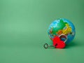 Heart shaped red lock with key and earth globe on a green background. Royalty Free Stock Photo