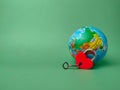 Heart shaped red lock with key and earth globe on a green background Royalty Free Stock Photo