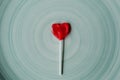 Heart shaped red lollipop on blue background. Valentines day and love concept. Heart shaped strawberry candy. Royalty Free Stock Photo