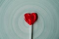 Heart shaped red lollipop on blue background. Valentines day and love concept. Heart shaped strawberry candy. Royalty Free Stock Photo