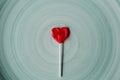 Heart shaped red lollipop on blue background. Valentines day and love concept. Heart shaped strawberry candy. Royalty Free Stock Photo