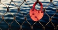 Heart-shaped red love lock hanging on a metal bridge railing Royalty Free Stock Photo