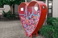 Heart shaped red recycling container for plastic caps outdoors