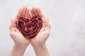 Heart shaped red veggie pasta made of beet in man hands.