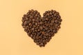 Heart shaped roasted coffee beans I love coffee on beige background