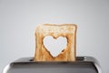 Heart shaped on roasted toasted bread in a toaster. Breakfast preparation on Valentine`s Day. symbol sign of love. Concept.