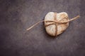 Heart shaped rock pebble tied with twine on dark blue purple stone background, conceptual, relationship, valentine, marriage Royalty Free Stock Photo