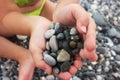 Heart shaped small pebbles in children`s hands