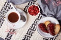 Heart shaped St Valentines cookies with raspberry taste with cup of coffee. Romantic holiday food background. Top view