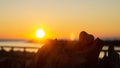 Heart shaped stone liyng treetrunk with sunset and as background