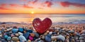 Heart-shaped stone on a pebble beach, illuminated by the warm colors of a sunset. Royalty Free Stock Photo