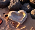 A heart-shaped stone rests on the sandy shore. Royalty Free Stock Photo