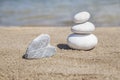 Heart shaped stone and stack of pebbles on balance on sandy beach Royalty Free Stock Photo