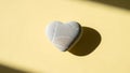 Heart-shaped stone on yellow background Royalty Free Stock Photo