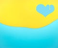 Heart shaped symbol made of dripping yellow paint on blue background Royalty Free Stock Photo