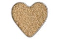 Heart shaped tin pan full of raw Thai half polished Brown Jasmine rice grains, isolated on white