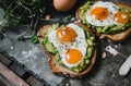 a heart shaped toast with avocado and eggs on top of a gray tile Royalty Free Stock Photo