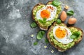 a heart shaped toast with avocado and eggs on top of a gray tile Royalty Free Stock Photo