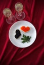 Heart shaped toasts with red and black caviar and two glasses of champagne on white plate on red drapery Royalty Free Stock Photo