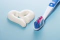 Heart shaped toothpaste and toothbrush on blue background, dental care concept Royalty Free Stock Photo