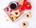 Heart shaped traditional linzer cookies with strawberry jam, mug of coffee and gift box. Valentine s day concept. Royalty Free Stock Photo